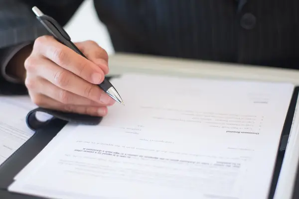 Persona revisando y firmando la documentación de una póliza