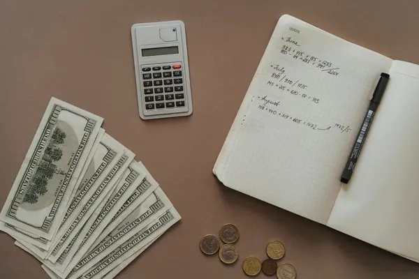 Cuaderno y dinero vistos desde arriba
